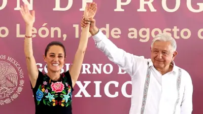 Andrés Manuel López Obrador holding up Claudia Sheumbaum's arms at an event back in August