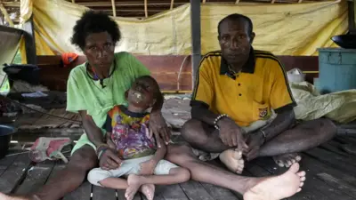 Keluarga Maurenus Merne tinggal di Kampung Anggreso, Kabupaten Mamberamo Raya. Anak bungsunya, Petra, lumpuh sejak balita dugaannya selama mengandung, mama Ester tidak mendapatkan asupan makanan bergizi dan vitamin yang memadai.