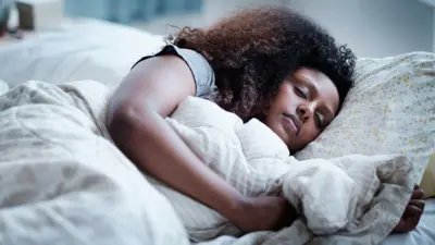 Umugore uryamye asinziriye