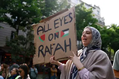 A woman holds a sign saying 'All Eyes on Rafah' at a protest at Sorbonne University, Paris