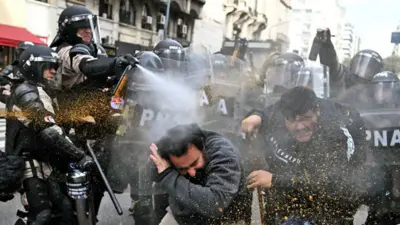 Riot police use pepper-spray on demonstrators during a protest outside the National Congress in Buenos Aires on September 11, 2024.