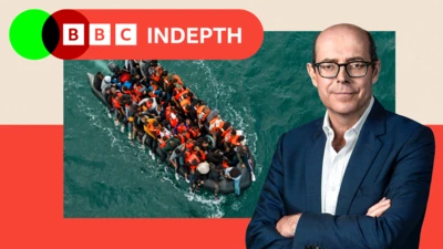 Composite featuring an aerial photo of a black rubber dinghy in the sea packed with around 50 people wearing lifejackets, in many cases with their legs hanging over the side of the boat. The 91ȱ presenter Nick Robinson is pictured separately to the right of the composite.