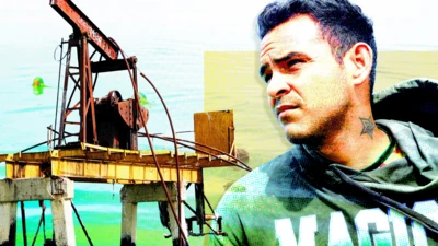 Una imagen diseñada muestra una vieja bomba de petróleo oxidada a la izquierda y un joven de cabello oscuro a la derecha. Mira con nostalgia hacia la distancia. Lleva puesta una sudadera gris con la palabra "magic" escrita en letras blancas y verdes.