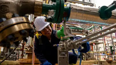 Um operário manuseia uma máquina em uma instalação industrial colombiana