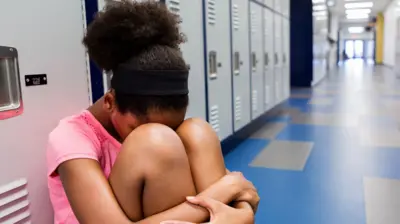 Girl wey dey hide her head for her legs or wetin look like school hall