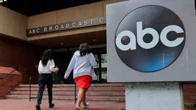 「ABC」の看板が出た建物に2人の人が入る様子