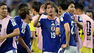 青色ユニホームの日本代表選手らとピンクのビブを着けた選手らが密集している