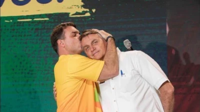 Flávio Bolsonaro beija a cabeça do pai Jair Bolsonaro, em imagem publicada pelo senador em seu Instagram