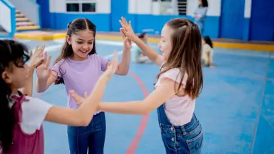 Meninas brincando dentro de um ginásio.