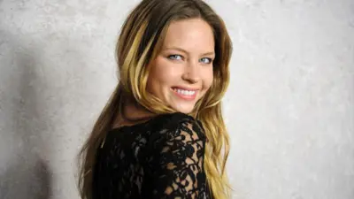 A atriz Daveigh Chase sorri enquanto olha por cima do ombro para a estreia de 2011 de sua série Big Love, da HBO. 