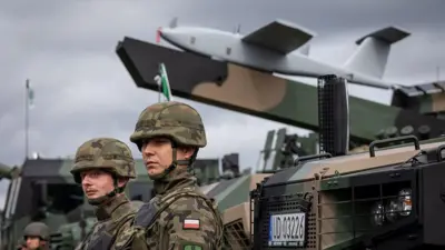 Polscy żołnierze stoją obok opancerzonego pojazdu wielozadaniowego „Waran” wyposażonego w system dronów Gladius, podczas pokazu sprzętu wojskowego po ćwiczeniach wojskowych Polski i państw sojuszniczych NATO w Orzyszu