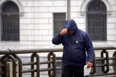 Homem se protege de chuva
