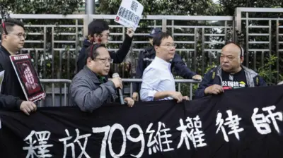 2018年12月26日，一群香港的示威者在中联办外拿起写有“释放709维权律师”的横额。