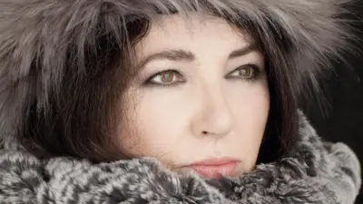 Handout photo of Kate Bush pictured in close-up wearing a hat and coat