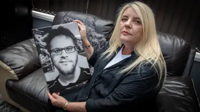 Angela Stevens holds a large photo of her son Brett