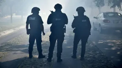 Tres policías, de espaldas en una calle