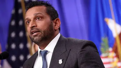 Kash Patel speaking em frente de uma bandeira dos EUA