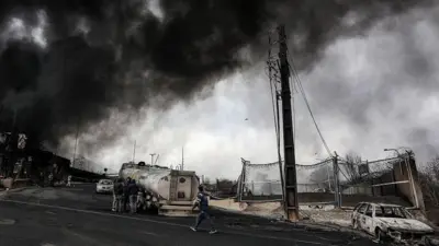 Обугленные машины и клубы дыма рядом с разбомбленным НПЗ "Шахран" в Тегеране