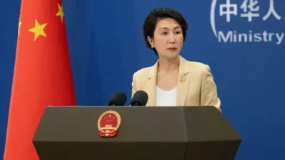 مائو نینگ، سخنگوی وزارت امور خارجه چین پشت میز خطابه قرار گرفته و در کنار او پرچم چین دیده می‌شود. 