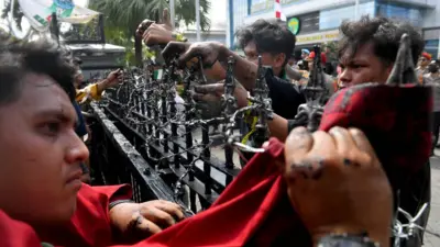 Masa aksi berusaha melepas kawat berduri saat unjuk rasa di depan kantor Gubernur Kalimantan Timur, Samarinda, Kalimantan Timur, Selasa (21/4/2026).