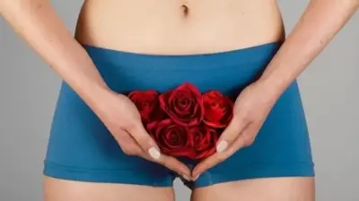 Umukobwa ufashe ururabyo rwi rose hagati y'amaguru