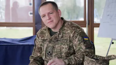 Александр Пивненко в военной форме сидит в помещении на фоне окна