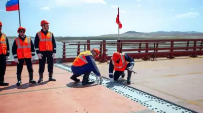 Dos funcionarios revisan los avances en el puente que se cosntruye entre Rusia y Corea del Norte. 