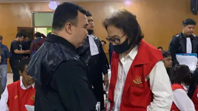 Pengacara dan kliennya berdiskusi di ruang sidang Pengadilan Negeri Bandung