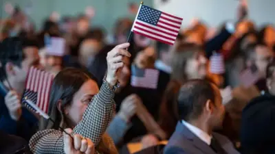 زنی در میان جمعیت که پرچم امریکا را در دست دارد.