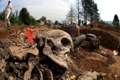 Especialistas escavam vala comum no vilarejo de Budak, perto da cidade de Srebrenica, em 2005