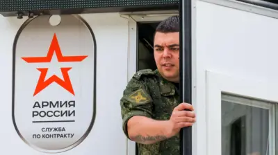 Мужчина с напряженным выражением на лице и в военной форме выходит из помещения с эмблемой «Армия России. Служба по контракту»
