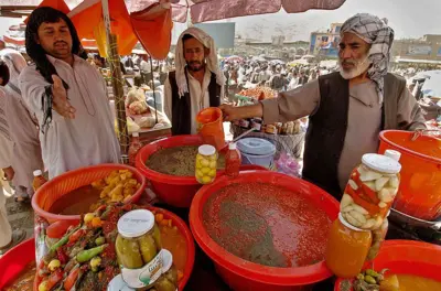  دوه سړي ولاړ دي او د روژه ماتي خواړه پلوري.