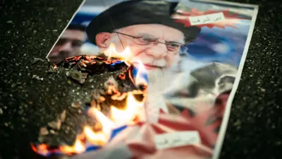 Горящий портрет верховного лидера Ирана во время акции протеста противников режима в Швейцарии