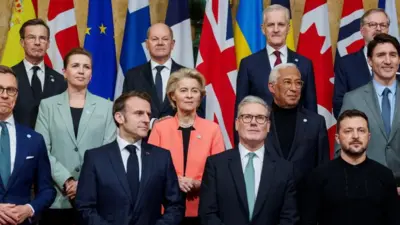 Keir Starmer in a dark suit poses for a group picture with European leaders 