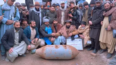 د شوروي اتحاد له یرغل څخه پاتې شوی بم، چې ځایی خلک او د ماین پاکۍ کارکونکي ترې شاوخوا راټول دي.