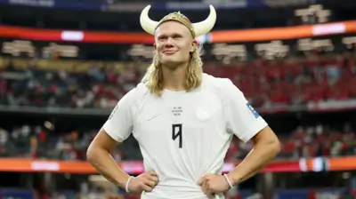 Erling Haaland usando um capacete de viking de plástico após a vitória da Noruega sobre a Costa do Marfim