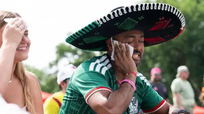 12 de junho de 2026. Torcedores enxugam o suor do rosto por causa do calor na Fifa Fan Zone, em Washington, DC, antes da partida de abertura da Copa do Mundo entre México e África do Sul.