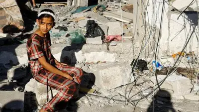 یک دختر فلسطینی در ویرانه‌های خانه‌ای در رفح