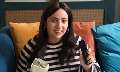 woman on sofa with remote control and popcorn