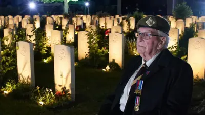 D-Day veteran Sergeant Richard Brock sits next to some of the 4,600 lit headstones during the Commonwealth War Graves Commission's Great Vigil to mark the 80th anniversary of D-Day at the Bayeux War Cemetery in Normandy, France.