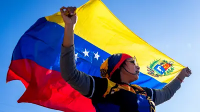 Una mujer con una bandera de Venezuela