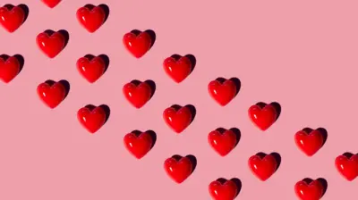 Köşegen üzerindeki kırmızı kalpçikler, pembe arka planda dizilmişler. 