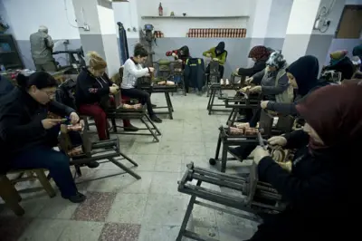 10 kadın bir atölyede yan yana oturmuş, önlerindeki bakırları işliyor