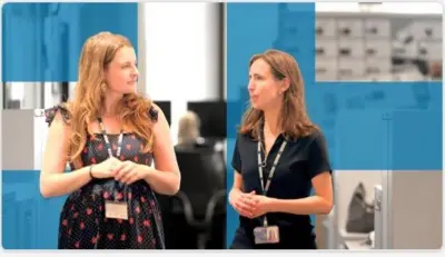 Two female colleagues walk together in conversation.