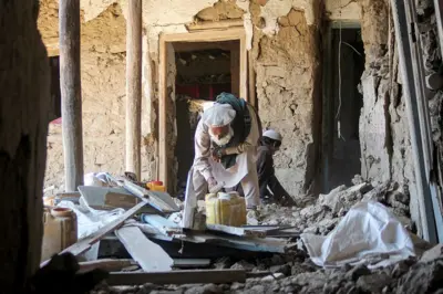 یک باشندهٔ ولسوالی مرور کنر در شرق افغانستان، جایی که پاکستان حمله هوایی کرد، در حال پاک‌سازی آوار خانه‌اش. ۲۹ جون ۲۰۲۶