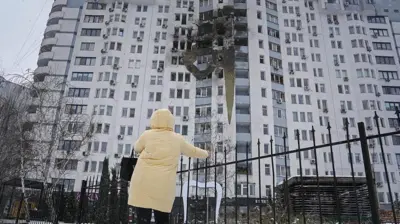 Mieszkanka ogląda zniszczenia budynku mieszkalnego po rosyjskim nalocie w Kijowie w piątek, 9 stycznia 2026 r. Rosyjskie Ministerstwo Obrony poinformowało o „masowym ataku z użyciem precyzyjnych, dalekosiężnych pocisków lądowych i morskich, w tym systemu Oresznik”.