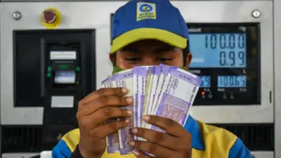 पेट्रोल पंप पर तेल गिरता एक कर्मी