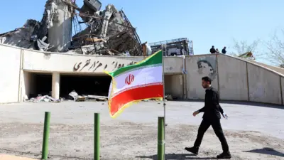 An Iranian official walks next to the damaged Azadi sports complex in Tehran, Iran (3 April 2026)