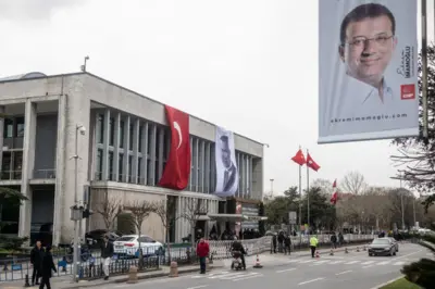 İBB'nin Saraçhane'deki merkez binası önünde yürüyenler ve bir polis 