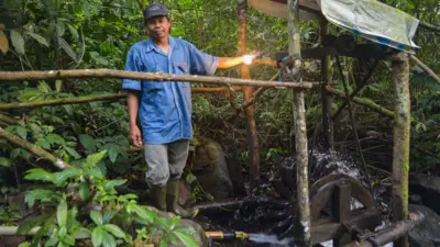 Penduduk Kampung Cisadon di samping kincir air pembangkit listrik.